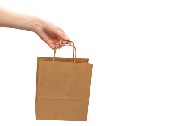 istock Paper bag in woman hands isolated on white background. 1298158549