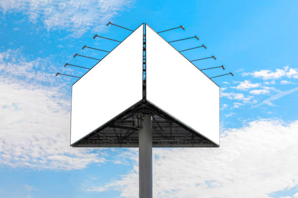 Advertising billboard against blue cloudy sky. Two white surfaces are at an angle to each other. Different viewing planes.