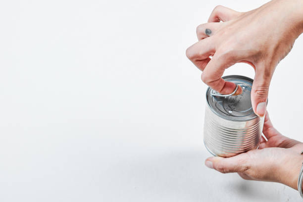 istock Hand holding a tin with boiled green peas on a white background 1298159456