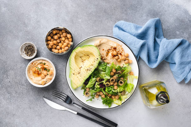 istock Vegetarian salad with chickpea hummus, greens and avocado 1298159771