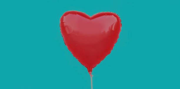 istock Red heart shaped balloon isolated on a blue background 1298159839