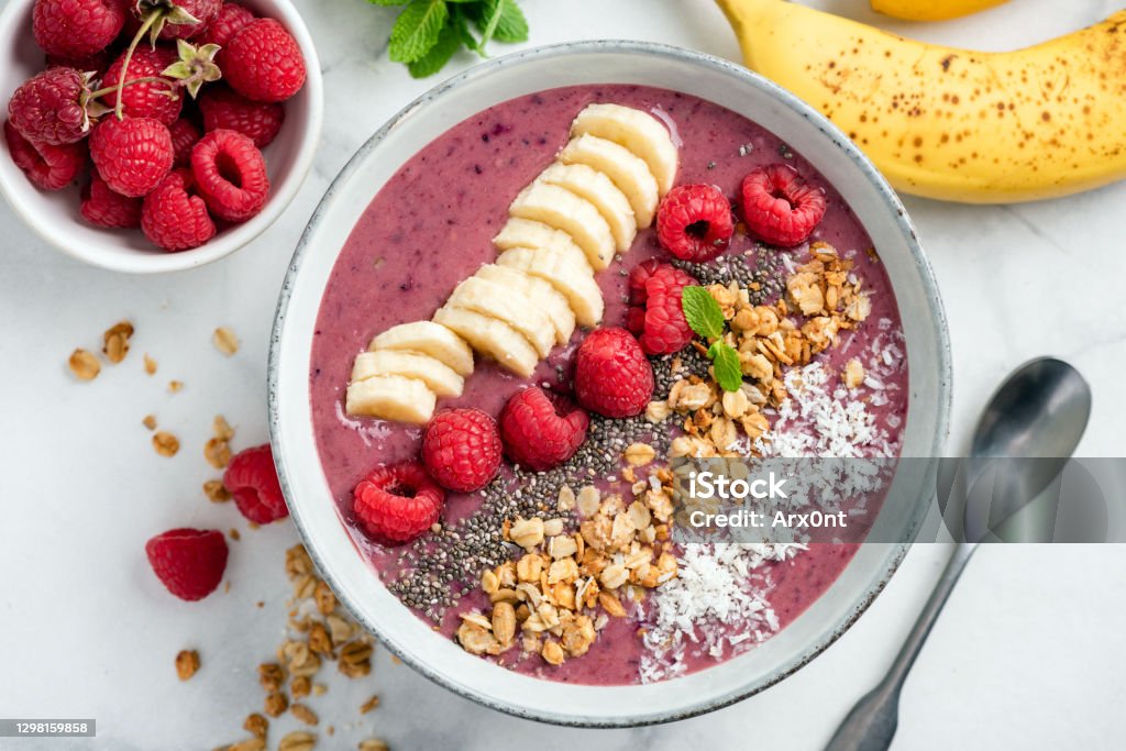 Acai Smoothie Bowl With Toppings Vegan Acai Smoothie Bowl With Toppings Banana Raspberry Granola Coconut. Top view Smoothie Stock Photo