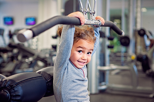 Portrait of little girl exercising in a gym