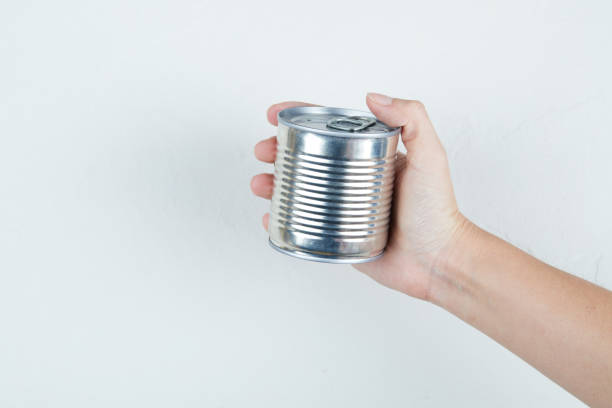 istock Hand holding a tin can of boiled sweet corn on a white background 1298161023