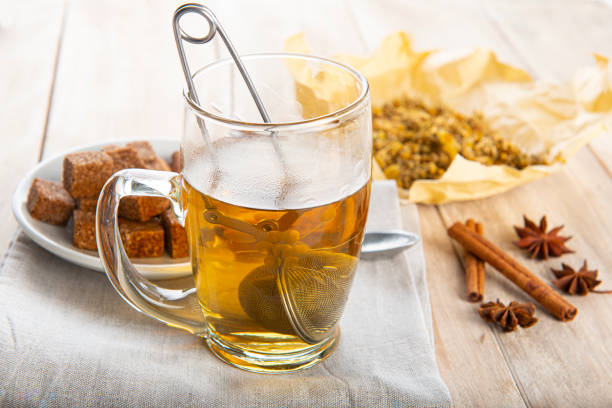 Hot chamomile tea made of wild flowers with a mesh ball tea infuser