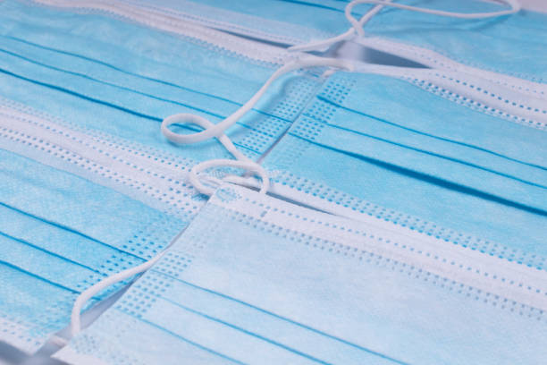 istock blue medical masks stacked next to each other 1298163832