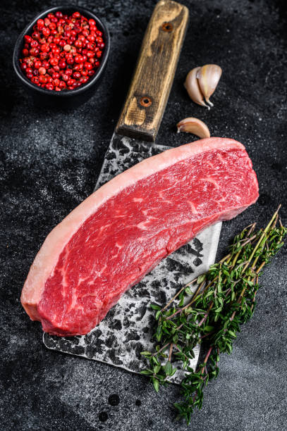 istock Raw cap rump beef meat steak on a butcher cleaver. Black background. Top view 1298165071