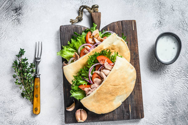 pita-sandwich mit gebratenem huhn, gemüse und köstlicher sauce. weißer hintergrund. ansicht von oben - pita stock-fotos und bilder