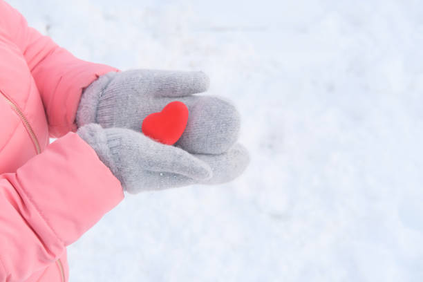 istock girl in a pink jacket holding a red heart model 1298165943