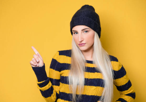 istock Young woman pointing up with forefinger to copy space - blank space for text, isolated on white background 1298166182