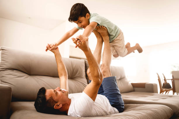istock father playing with his son in the home room 1298167319