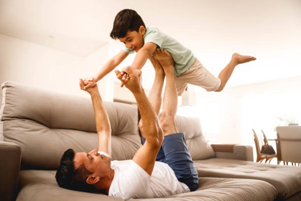 istock father playing with his son in the home room 1298167323