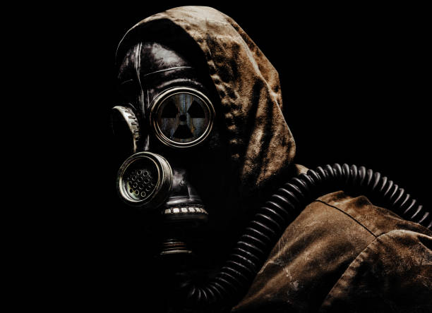 Stalker warrior in protective soviet gas mask standing on dark background. stock photo