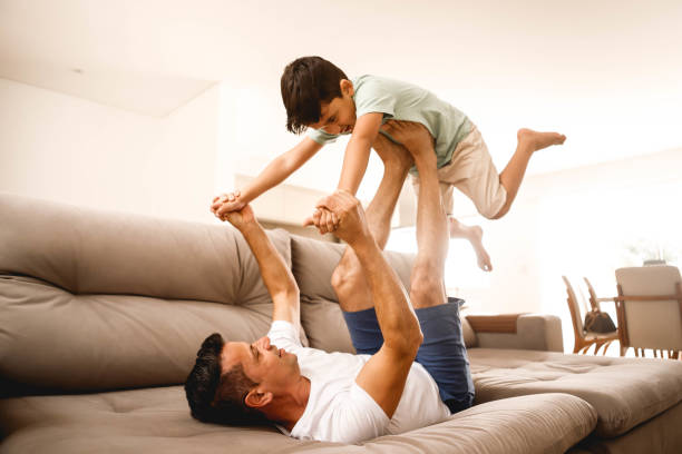 istock father playing with his son in the home room 1298167374