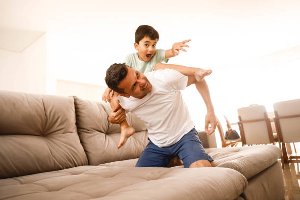 istock father playing with his son in the home room 1298167419
