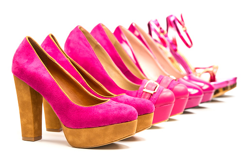 Close-up studio shot  of various stiletto high heels in in pink color, lots of copy space.