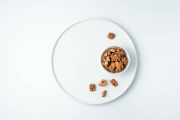 istock Peeled walnuts on a white background. The view from the top 1298168685
