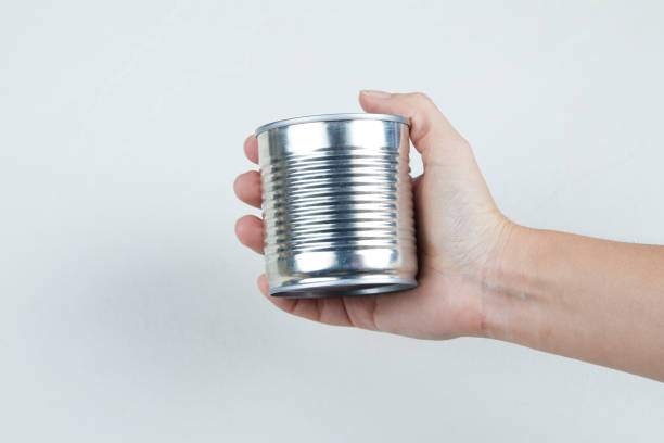 istock Hand holding a tin can of boiled sweet corn on a white background 1298173912