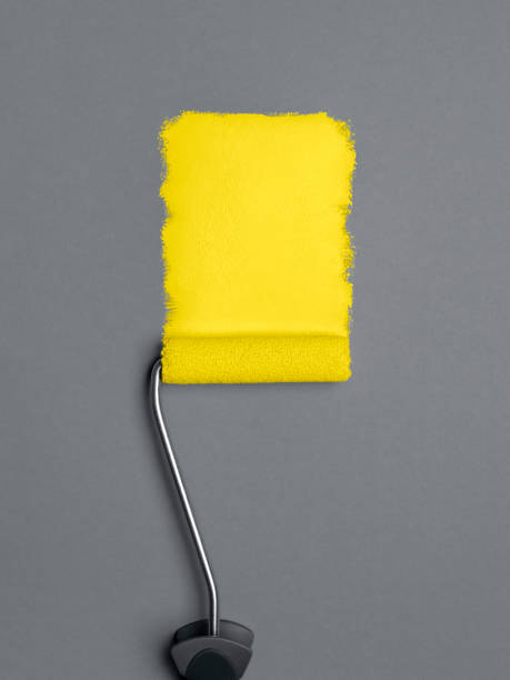 tratto di vernice giallo con pennello a rullo su sfondo grigio. pittura di colore giallo - pantone 2021 foto e immagini stock