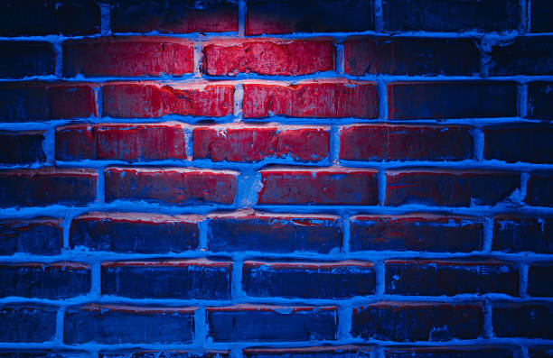 istock Brick wall texture background in red and blue neon lights 1298180247
