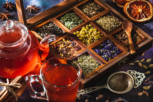 Red tea with a box of tea herbs and aromatic spices with glass teapot and teacup