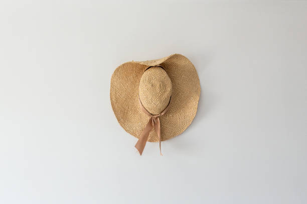 Headdress straw hat, beige panama hanging on the wall in a horizontal position. stock photo