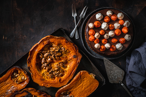 Pumpkin and chocolate cake with roasted butternut squash and pumpkin in a tray an autumn meal