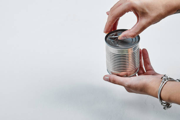 istock Hand holding a tin with boiled green peas on a white background 1298182679