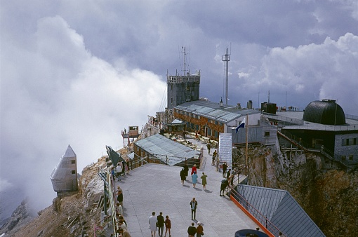 Garmisch-Partenkirchen, Bavaria, Germany, 1975. Viewing platform with tourists on the alpine summit of the Zugspitze. On the day of the recordings, a low ran along the Eastern Alps and prevented a wide view over the Wetterstein Mountains.