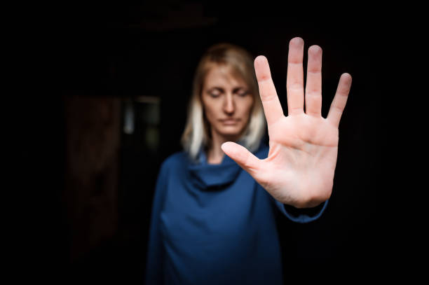 giovane donna che mostra il segno stop con il palmo della mano - violenza donne foto e immagini stock