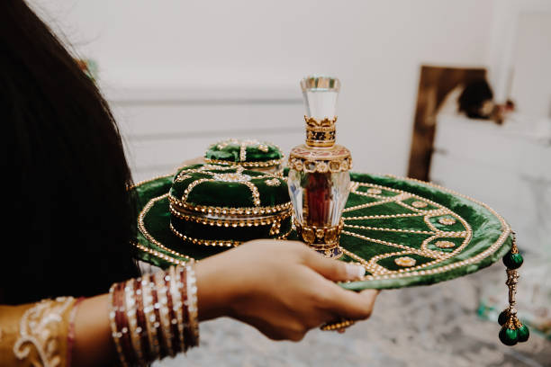 Female hands with round golden emerald green velvet indian tray stock photo
