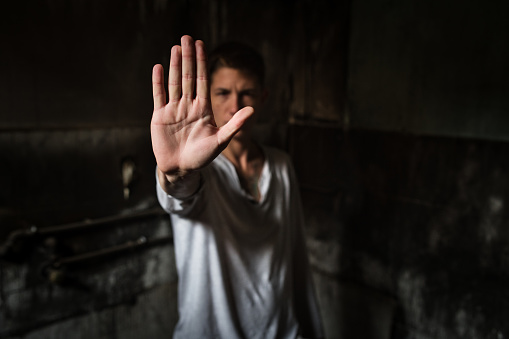 Close-up of a young man making a stop gesture.