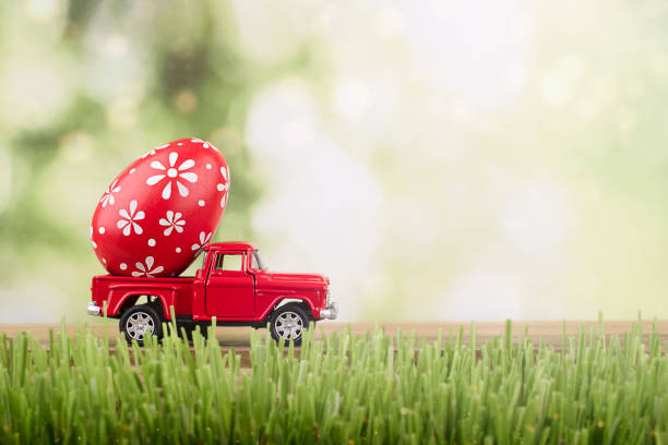 toy car carrying an easter egg - easter egg easter grass spring imagens e fotografias de stock