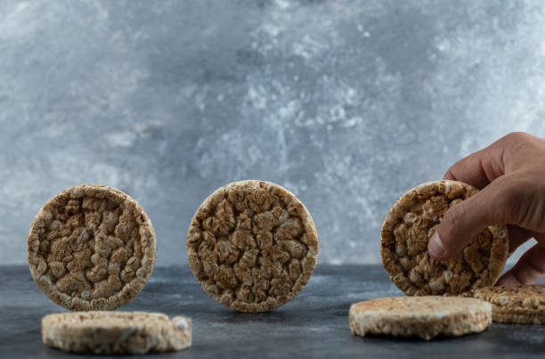 istock Male hands holding round crispbread on marble background 1298188797