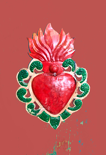 Antique Red Milagros Heart on Red-Brown Background