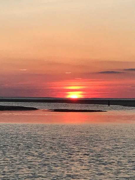 istock Red Cloudy Sky Sunset Dusk Kissing The Water 1298189427