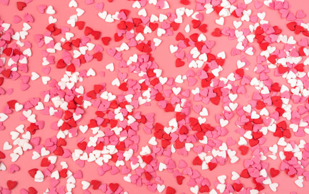 istock Romantic background with small hearts on pink background. The view from the top 1298192611