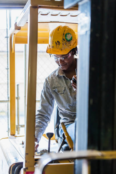 istock Black woman driving forklift in warehouse 1298192638