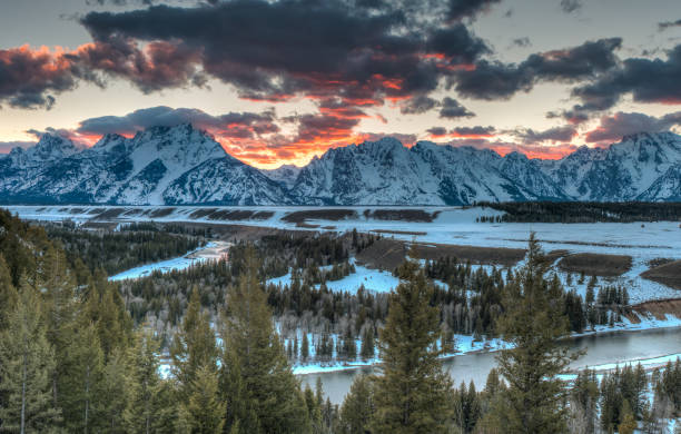 Stunning sunset over the Grand Teton The clouds light up the sky as the sun sets behind the Grand Teton in Jackson Hole Wyoming snake river valley grand teton national park stock pictures, royalty-free photos & images