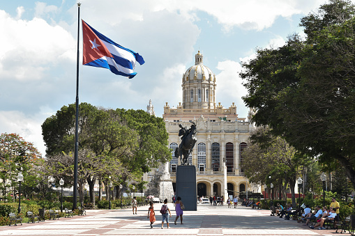 Havana, Cuba - May 10, 2019: The Museo de la Revolución (Museum of the Revolution), which is housed in the former Presidential Palace, seen from Plaza 13 de Marzo, with a Cuban flag and the equestrian statue of José Martí.