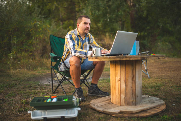 istock Young man working on his laptop in the nature 1298198854
