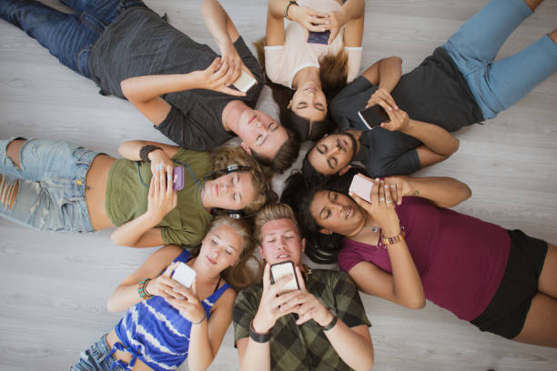 istock Overhead view of teenagers using mobile phones 1298199566