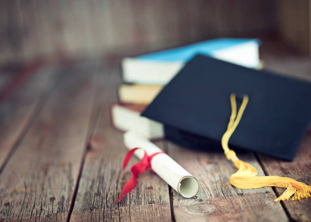 Mortarboard and graduation scroll tied with blue ribbon.