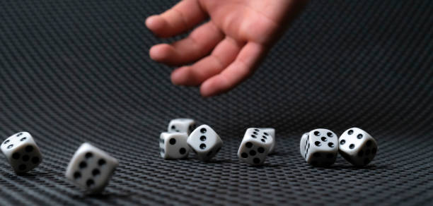 istock person's hand roll the dice cubes on the table, win gamble casino 1298199915