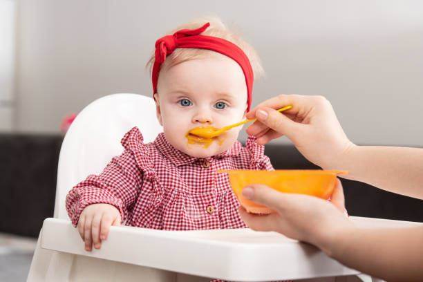 istock Mother Feeding Her Little Baby At Home 1298200041