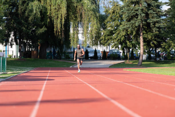 istock Young Man Is Jogging on Sunny Day 1298200103