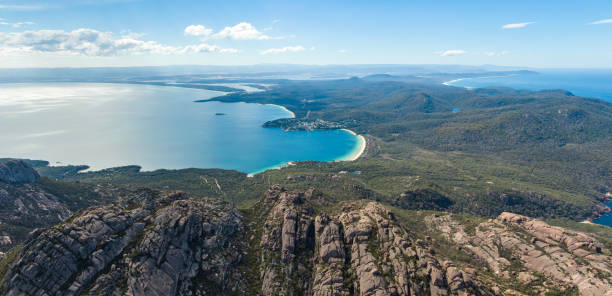 bellissima vista panoramica con droni aerei ad alto angolo della baia di coles e del parco nazionale di freycinet con richardsons beach e coles bay village. la famosa catena montuosa di hazards in primo piano. - freycinet national park foto e immagini stock