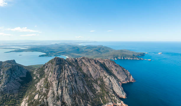 bellissima vista panoramica con droni aerei ad alto angolo della baia di coles e del parco nazionale di freycinet con richardsons beach a sinistra e cape tourville sulla destra. famosa catena montuosa di hazards in primo piano. - freycinet national park foto e immagini stock