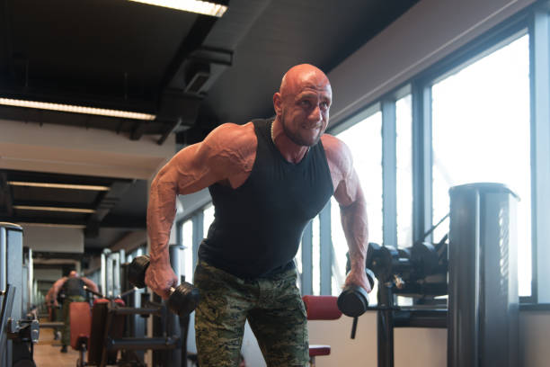 istock Man With Dumbbells Exercising Shoulders 1298205174