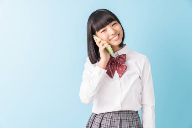 istock girl student who talks on the telephone,School uniform, 1298207636